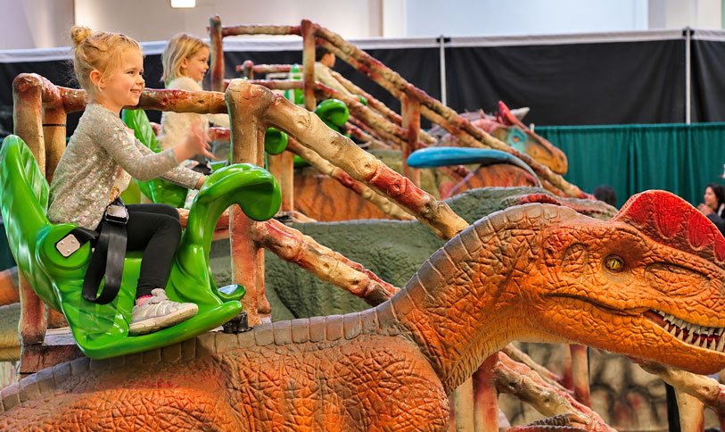 Child riding a dinosaur ride at Dinosaur Adventure